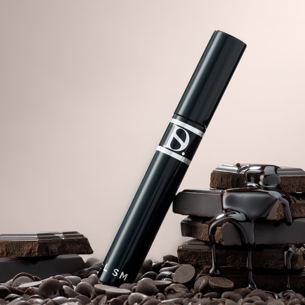 Creative hero product photography showing a mascara with bold colour backdrop and dramatic lighting